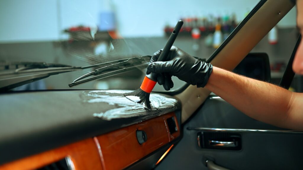 Porentiefe Reinigung und Materialpflege des Cockpits mit Spezialpinsel bei Autoaufbereitung Harms.